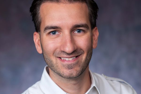 Filippo Trevisan is a white man with short dark hair and blue eyes. He's wearing a white shirt.