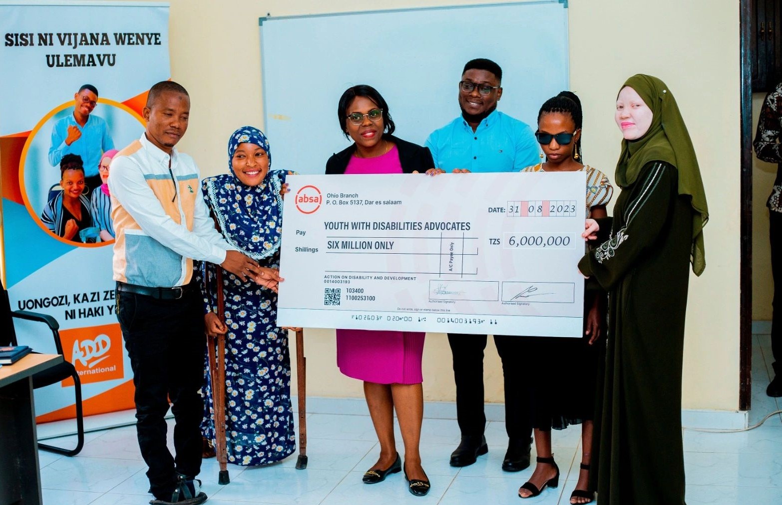 Group of grant recipients smiles while holding a large check