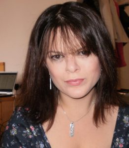 Young woman with long dark hair looking directly into camera